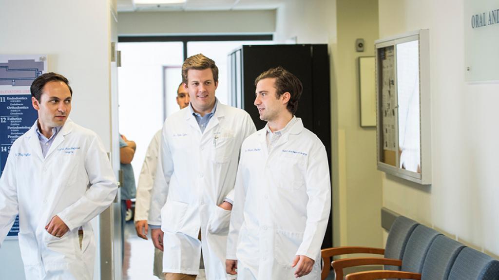 Oral surgery students walking and talking in a hallway