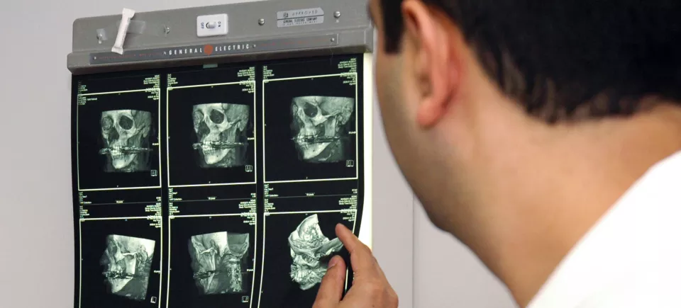 A dental faculty member reviewing cranial x-rays