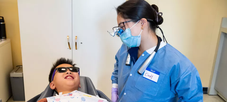 Cindy Phan, D26, provides dental care to a child during a routine checkup