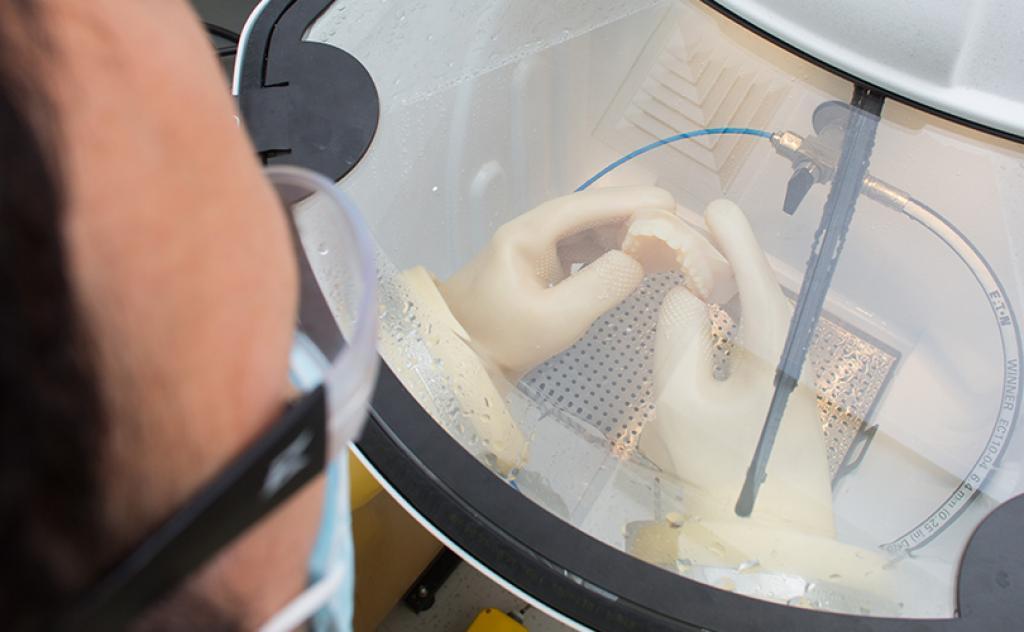 Student using a 3D printer to make dentures