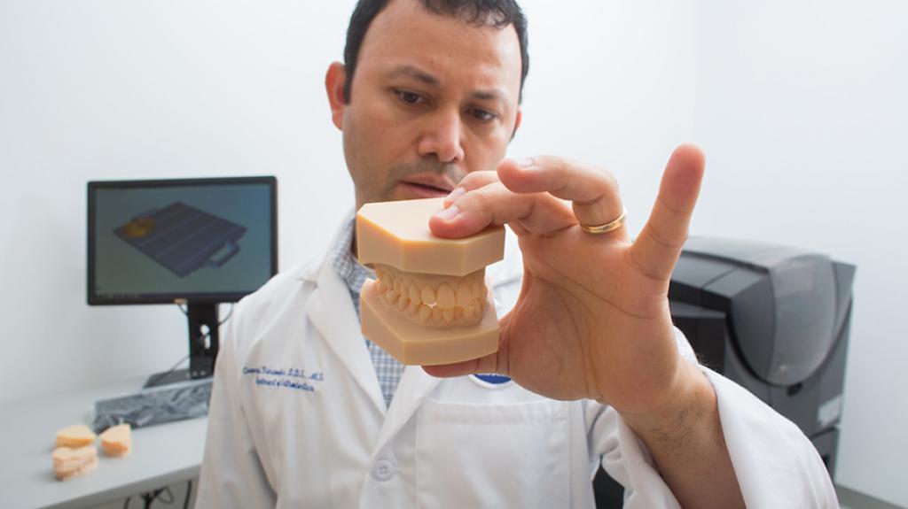 Dentist reviewing a clay model of teeth