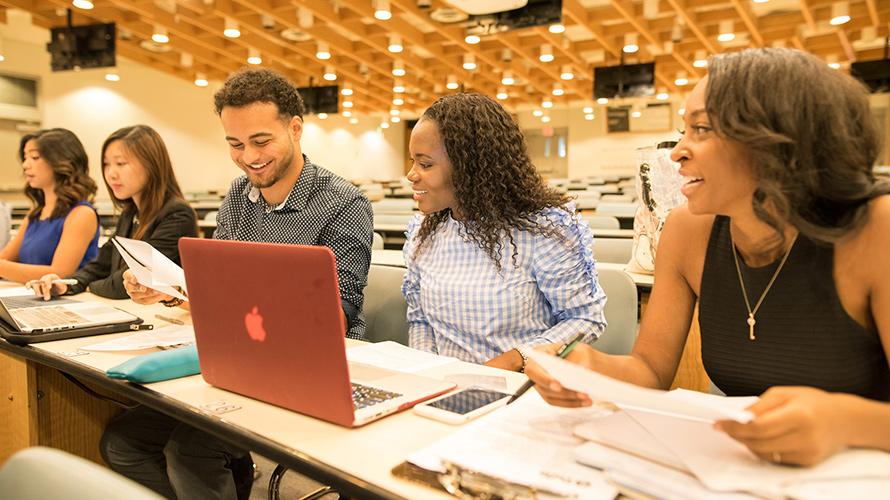 Diverse students talking and studying while sitting in a classroom