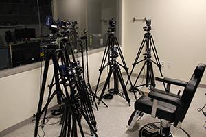 Video cameras on tripods surrounding a chair