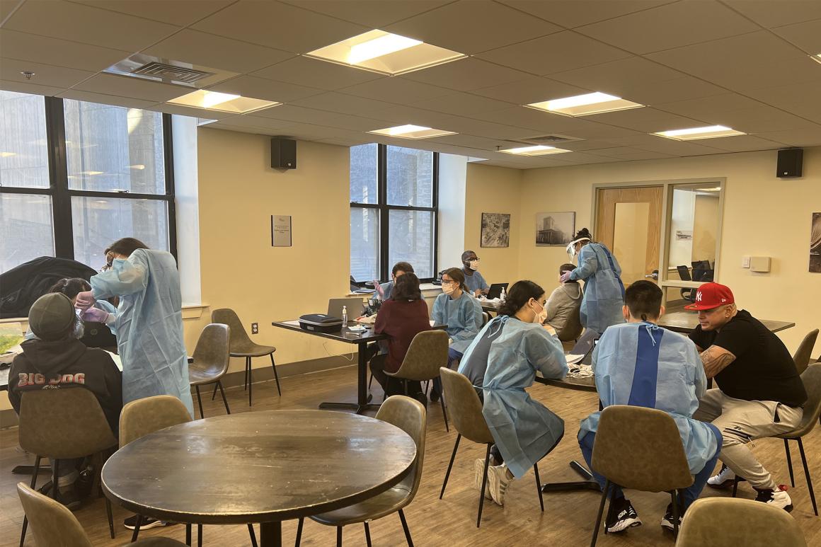 Dentists sitting with groups of people in a large room and circular tables