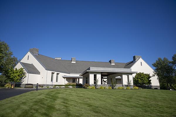 outside of a white clubhouse on a golf course