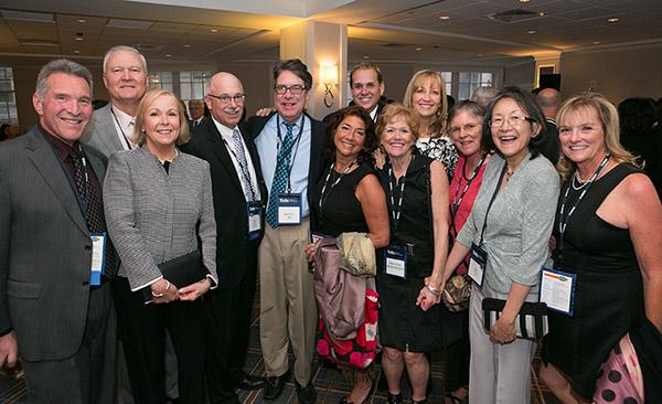 A group of people standing and smiling, at a recent Tufts University School of Dental Medicine Alumni Reunion