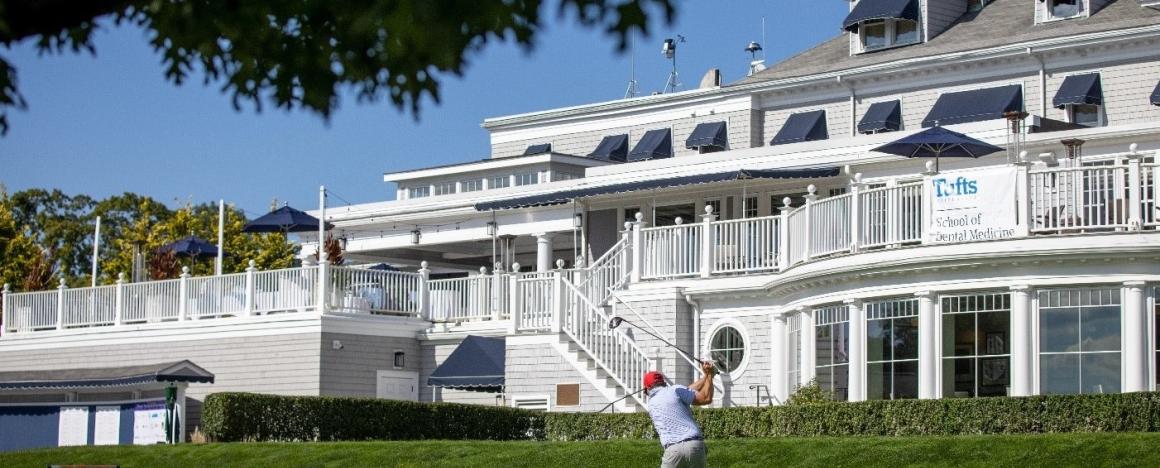 Golfer in front of white building