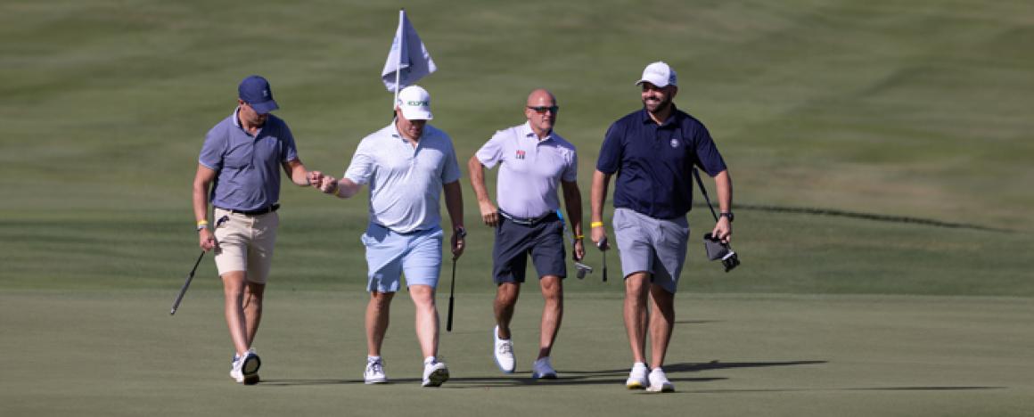 Golf players fist bump on putting green