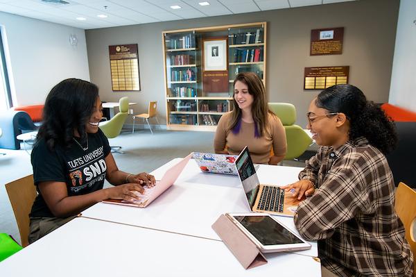 three women on laptops in student lounge
