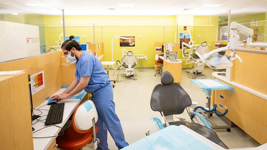 Student sets up a dental chair for incoming patients.