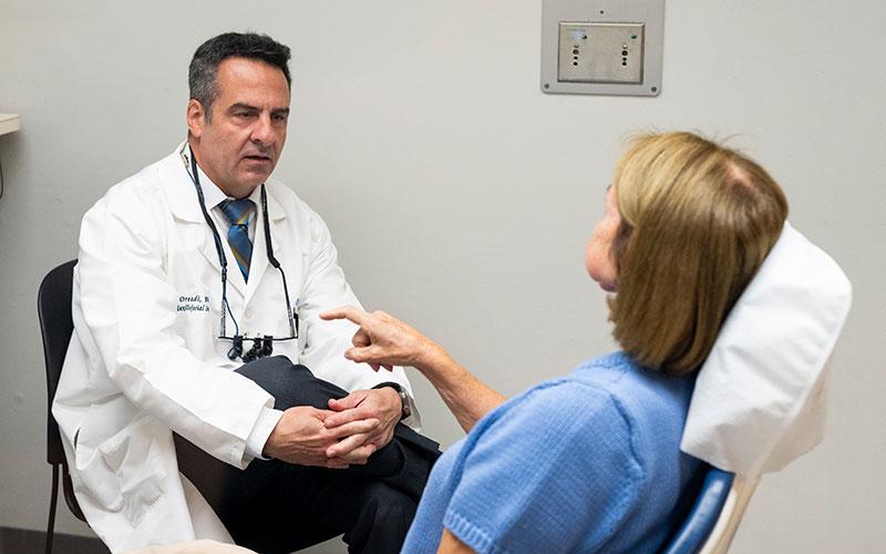 Dr. Daniel Oreadi, Associate Professor of Oral and Maxillofacial Surgery, poses for a photo with his patient at the Tufts University School of Dental Medicine 
