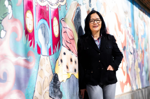 Tufts University School of Dental Medicine Professor Cheen Loo stands by a mural in Boston&#039;s Chinatown.  