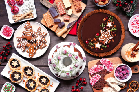 A table filled with many holiday desserts, pies, and candy.